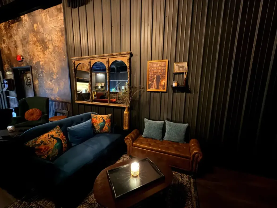 A speakeasy seating nook with a velvet sofa and an ornate mirror